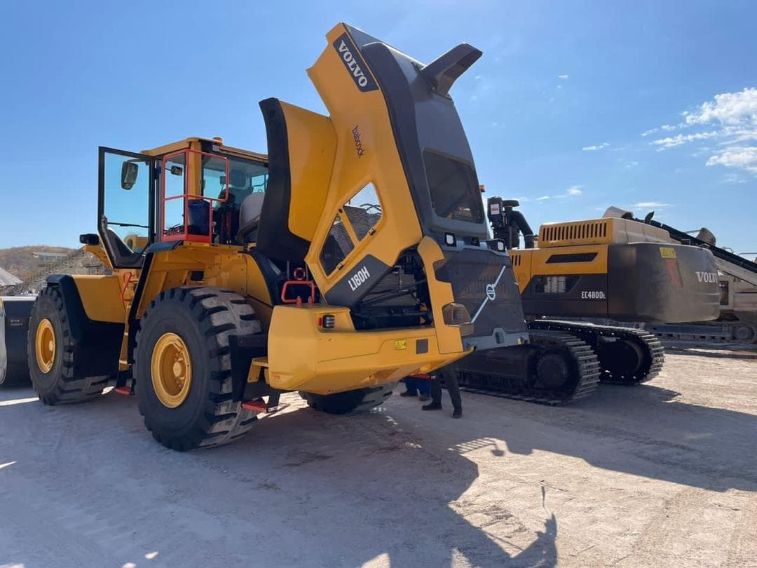 Volvo wheel loader positioned beside an excavator in a working yard