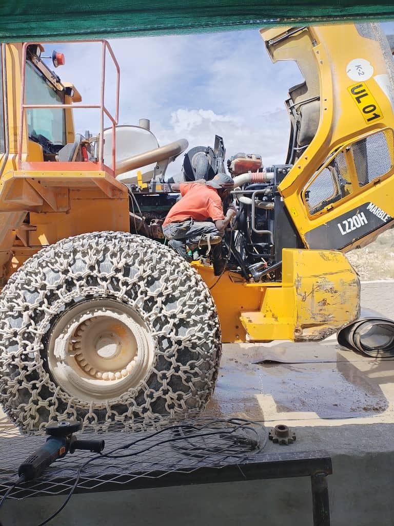 Technician servicing a wheel loader in the field